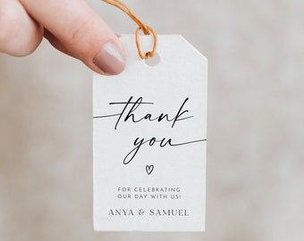 May include: White thank you tag with black calligraphy that says "thank you" with a small heart below. The text below the heart says "For celebrating our day with us! Anya & Samuel"