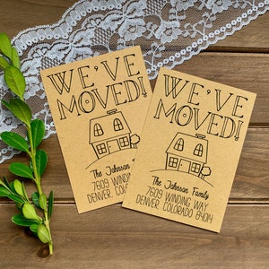 May include: Two brown cards with the text "We've Moved!" in black handwritten font. Each card features a simple black line drawing of a house with a tree in front. The cards include the text "The Johnson" and "The Johnson Family" with their new address in Denver, Colorado.