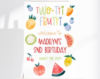 May include: A white rectangular sign featuring colorful watercolor fruit illustrations and the text: TWO-TTI FRUTTI welcome to MADELYN'S 2ND BIRTHDAY AUGUST 2ND, 2024. The design includes images of a pineapple, orange slice, watermelon slice, lemon, peach, and cherries.