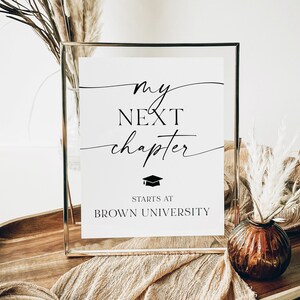 May include: A white sign in a silver frame with the text "my next chapter starts at BROWN UNIVERSITY" and a graduation cap icon.