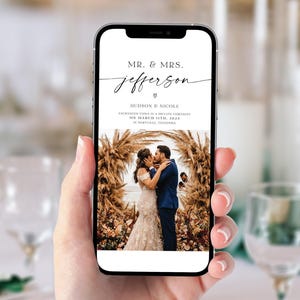May include: A wedding announcement on a mobile phone screen. The announcement reads "Mr. & Mrs. Jefferson" with a heart symbol. The text below reads "Hudson & Nicole" and "Exchanged vows in a private ceremony on March 11th, 2023 in Maryville, Tennessee". A photo of the couple kissing under a floral archway is displayed below the text.