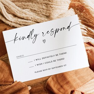 May include: White RSVP card with black text that reads "kindly respond" with a small heart symbol. The text below asks for the name(s) of the guest(s) and provides two options for responding: "I will definitely be there!" or "I wish I could be there!" The card also includes the instruction to RSVP by September 1st.