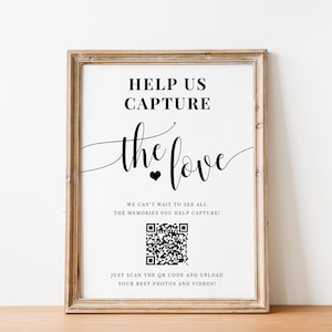 Può includere: Un cartello in bianco e nero con il testo "Help us capture the love" e un codice QR. Il testo "We can't wait to see all the memories you help capture!" e "Just scan the QR code and upload your best photos and videos!" è incluso.