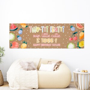 May include: A rectangular banner with a brown background featuring white polka dots and colorful watercolor fruit illustrations. The text reads: TWO-TTI FRUTTI our little cutie IS TURNING 2 HAPPY BIRTHDAY TAYLOR in various pastel colors.