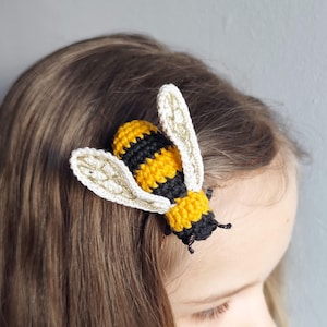 Puede incluir: Pinza de pelo de abeja hecha a mano con ganchillo. La abeja tiene rayas amarillas y negras en el cuerpo, con alas color crema. Sujeta a cabello casta&ntilde;o, creando un accesorio caprichoso.