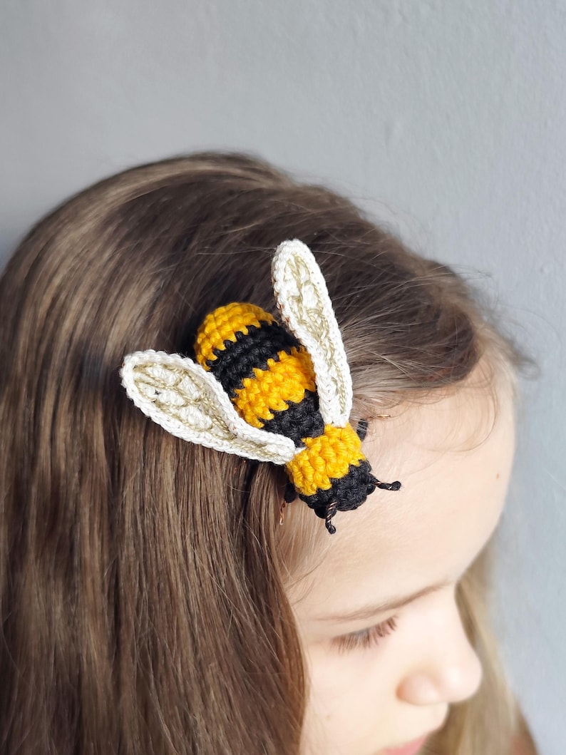 Puede incluir: Pinza de pelo de abeja hecha a mano con ganchillo. La abeja tiene rayas amarillas y negras en el cuerpo, con alas color crema. Sujeta a cabello casta&ntilde;o, creando un accesorio caprichoso.