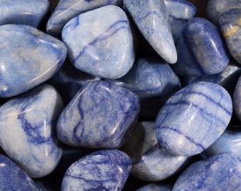 May include: A collection of blue and white tumbled stones. The stones have a smooth, polished surface and are a light blue colour with white streaks.