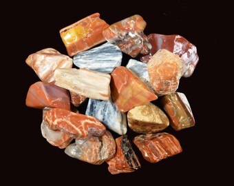 May include: A collection of colourful, polished, and tumbled stones. The stones are various shades of red, orange, brown, and white. The stones are smooth and have a natural, organic look.