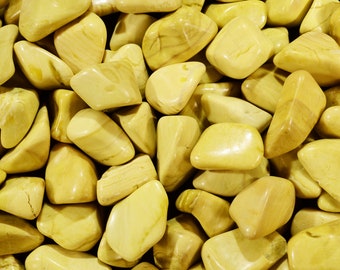 May include: A close-up of a pile of yellow tumbled stones. The stones are smooth and have a slightly translucent appearance.