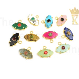 Könnte beinhalten: Sortiment von 12 vergoldeten bösen Augen-Anhängern mit verschiedenen farbigen Steinen. Jeder Anhänger hat ein Auge aus Edelstein mit einem kleineren Edelstein in der Mitte. Die Anhänger sind perfekt für die Schmuckherstellung oder um jedem Bastelprojekt eine einzigartige Note zu verleihen.