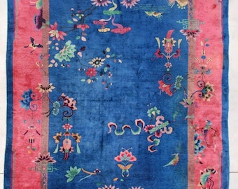 May include: A vintage Chinese rug with a blue background and a pink border. The rug features intricate floral and bird designs in shades of pink, green, and blue.