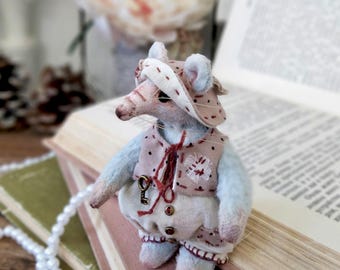A miniature plush gray rat figure with removable clothing
