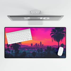 May include: A pink and purple sunset over a city skyline with palm trees. The cityscape is silhouetted against the sunset. A white keyboard and a white mouse are on the desk.