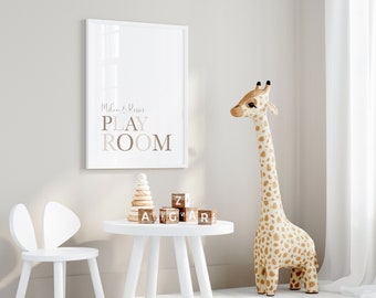 May include: A white framed print with the text "Milan & Reign PLAYROOM" hanging on a white wall. A white table with wooden blocks that spell "ZAKGWAR" and a wooden stacking toy sits on the table. A white chair with bunny ears sits next to the table. A stuffed giraffe stands next to the table.