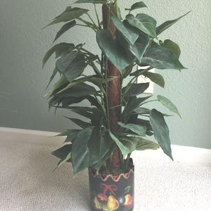 Vintage künstliche Philodendron-Pflanze in einem ausgebogten schwarzen Zinn-Toleware-Topf.  Etwa 2000.