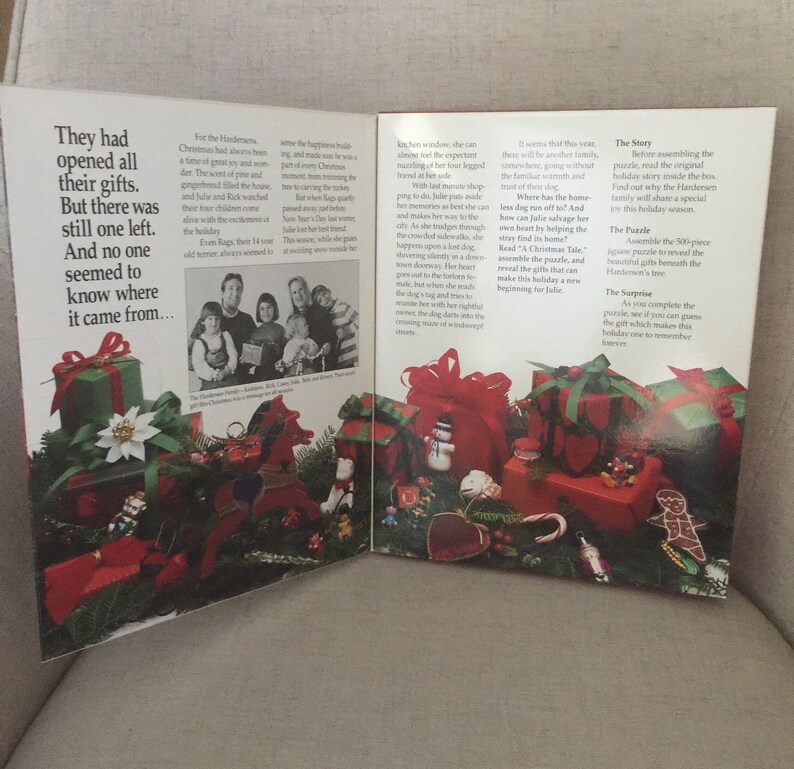 K&ouml;nnte beinhalten: Ein offenes Buch mit einer weihnachtlichen Illustration auf dem Umschlag. Das Buch zeigt ein rotes und gr&uuml;nes Farbschema mit einer Vielzahl von Weihnachtsdekorationen, darunter Geschenke, einen Schneemann und einen Zuckerstock. Der Text auf dem Umschlag lautet "Die Geschichte" und "Das Puzzle".