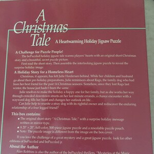 K&ouml;nnte beinhalten: Ein roter und wei&szlig;er Buchumschlag mit dem Titel "A Christmas Tale" und dem Untertitel "A Heartwarming Holiday Jigsaw Puzzle". Der Buchumschlag zeigt eine festliche Weihnachtsszene mit einem Hund und einer Frau.
