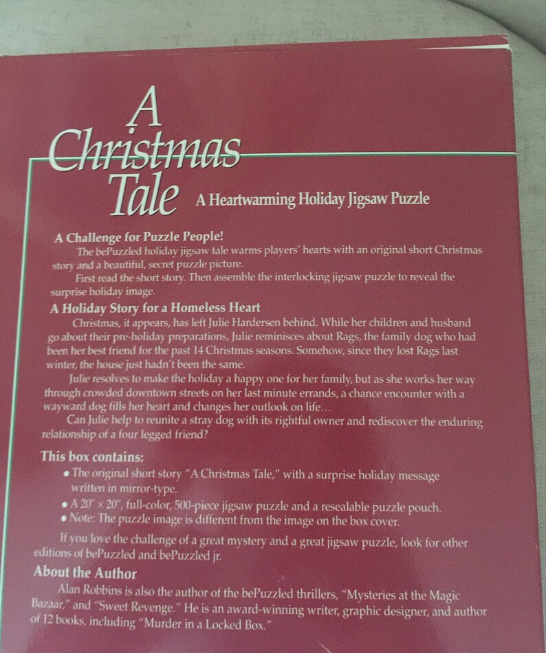 K&ouml;nnte beinhalten: Ein roter und wei&szlig;er Buchumschlag mit dem Titel "A Christmas Tale" und dem Untertitel "A Heartwarming Holiday Jigsaw Puzzle". Der Buchumschlag zeigt eine festliche Weihnachtsszene mit einem Hund und einer Frau.