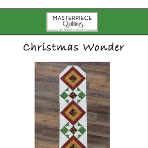 Może przedstawiać: Bieżnik na stół o tematyce świątecznej z białym tłem i powtarzającym się wzorem czerwonych, zielonych i złotych rombów. Bieżnik ma szerokość 45,7 cm i długość 167,6 cm. Tekst "Christmas Wonder" znajduje się w górnej części obrazu.