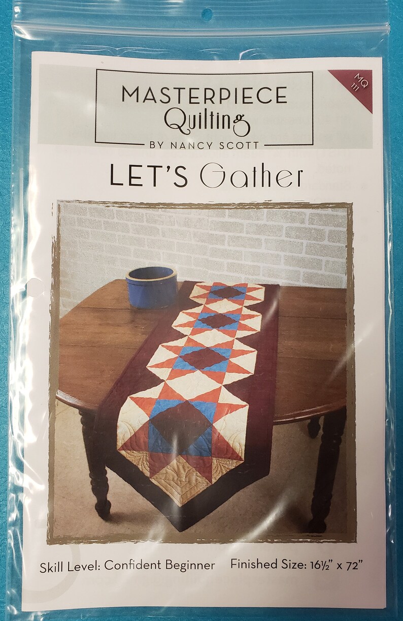 May include: A quilting pattern for a table runner called "Let's Gather" by Nancy Scott. The pattern features a red, blue, and white quilt design with a burgundy border. The finished size is 16 1/2 inches by 72 inches.