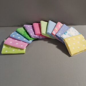 May include: A set of 10 fabric squares in various pastel colors with different patterns, including polka dots, floral designs, and a baby-themed print.