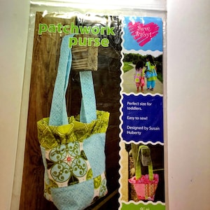 May include: A patchwork purse pattern in a clear plastic package. The purse is blue, green, and patterned. The package includes the text "patchwork purse" and "Sew Baby!" The pattern is designed for toddlers and is easy to sew.