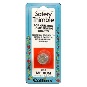 May include: A silver metal thimble with a textured surface. The thimble is labeled "Safety Thimble" and "Zinc Medium". The packaging is blue and red with white text and a floral border.