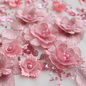 May include: Pink floral embroidery with sequins and pearl accents on a sheer mesh fabric.