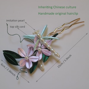 Puede incluir: Una horquilla hecha a mano con un dise&ntilde;o de lib&eacute;lula, perlas de imitaci&oacute;n y cord&oacute;n de seda. El accesorio para el cabello incluye flores rosas y hojas verdes. La horquilla mide 15 cm de largo y 6 cm de ancho. Texto: Inheriting Chinese culture, Handmade original hairclip.