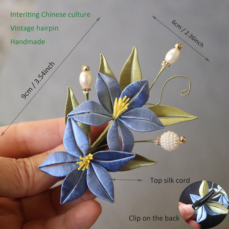 May include: A handmade blue silk flower hair clip with a vintage hairpin design. The clip is 9 cm / 3.54 inches tall and 6 cm / 2.36 inches wide. It features a top silk cord and a clip on the back.