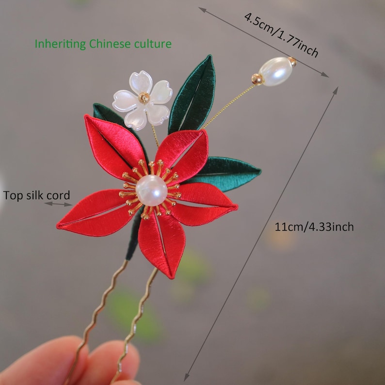 May include: Red and green silk flower hair pin with a pearl accent. The pin is 4.33 inches long and 1.77 inches wide.  "Inheriting Chinese culture" is written in green text on the image.