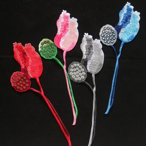 May include: Five embroidered iron-on patches featuring lotus flowers in various colors, including red, pink, green, gray, and blue. Each patch has a stem and a seed pod.