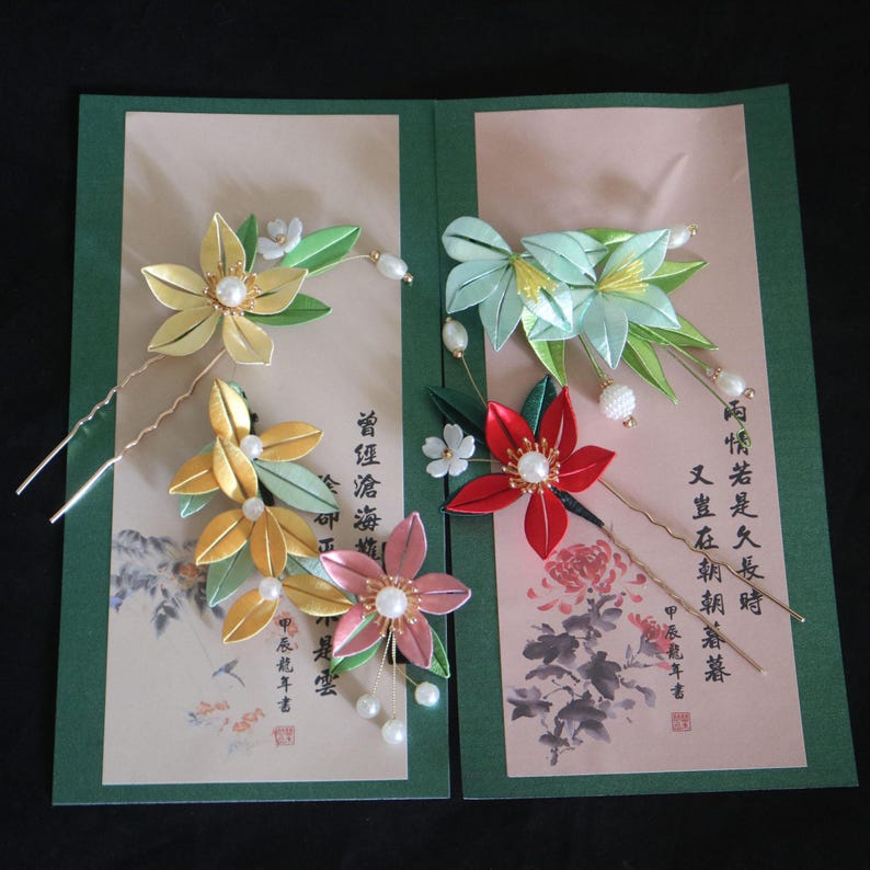 May include: Set of five handmade silk flower hair pins. The pins feature delicate flowers in shades of green, yellow, pink, and red with pearl accents. The pins are displayed on a card with Japanese calligraphy.