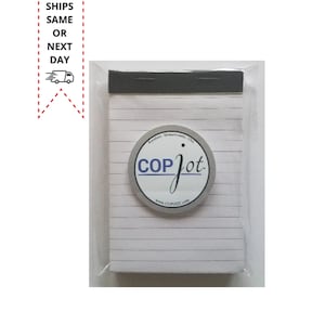 May include: A white lined notepad with a gray plastic cover and a black plastic clip. The notepad has a round sticker on the front with the text "Cop Jot" and the website address "www.copjot.com".