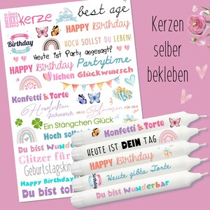Pode incluir: Um conjunto de velas de aniversário brancas com texto colorido e autocolantes decorativos. Os autocolantes apresentam frases como "Feliz Aniversário", borboletas, arco-íris e ilustrações de presentes. As velas estão dispostas sobre um fundo rosa.