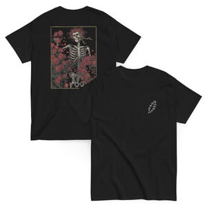 May include: Two black t-shirts. One features a skeleton design surrounded by red roses within a gold frame. The other shirt has a white lightning bolt design on the chest. Both shirts are short-sleeved.