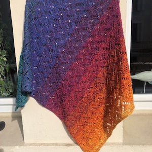 May include: A colorful crocheted shawl with a gradient of blue, purple, orange, and yellow.