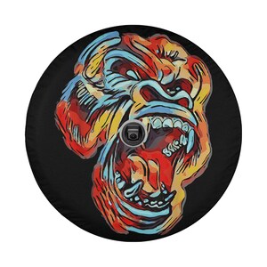 May include: A colorful illustration of a gorilla's face with its mouth open, revealing sharp teeth. The gorilla's face is painted in shades of red, orange, yellow, blue, and black against a black background.
