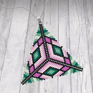 May include: A triangular pendant made of pink, green, and black beads. The pendant is in the shape of a pyramid and has a geometric pattern.