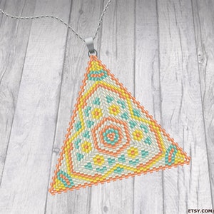 Peut inclure: Un collier avec un pendentif triangulaire en perles, avec un motif géométrique dans les tons orange, jaune et turquoise. Le pendentif est fait de perles de rocaille et est attaché à une chaîne argentée.