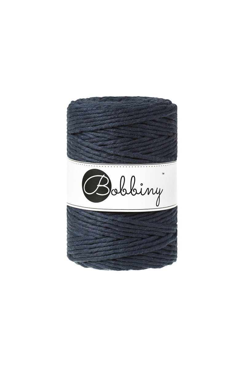 May include: A spool of dark blue cotton rope with the brand name "Bobbiny" printed on a white label.