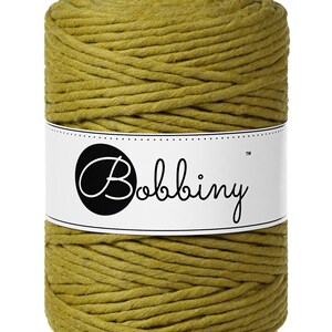May include: A spool of mustard yellow cotton cord, wrapped in a white label with the text "Bobbiny&trade;".