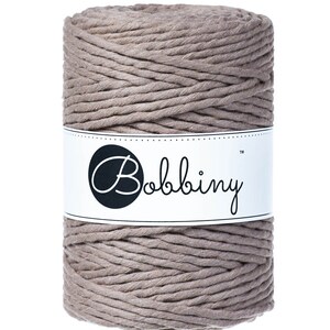 May include: A spool of thick, natural-colored cotton rope with a white label that reads "Bobbiny&trade;".