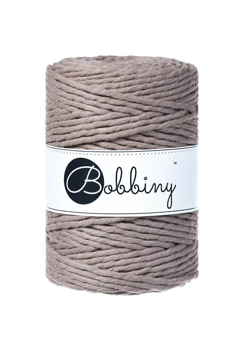 May include: A spool of thick, natural-colored cotton rope with a white label that reads "Bobbiny&trade;".