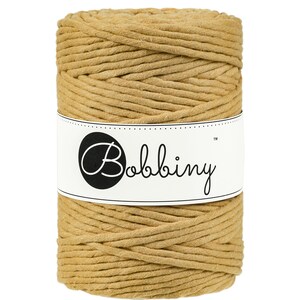May include: A spool of tan cotton cord, wrapped in a white label with the text "Bobbiny&trade;".