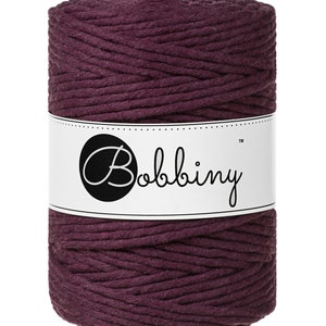 May include: A spool of deep purple cotton rope with the brand name "Bobbiny" printed on a white label.