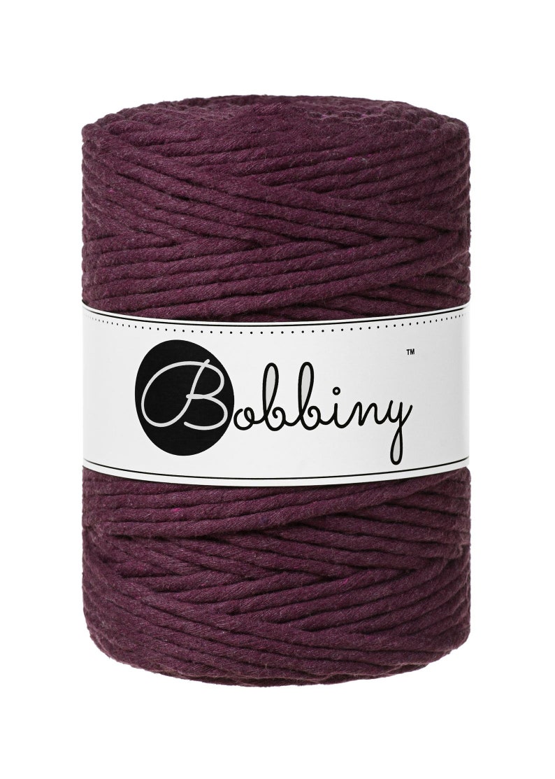 May include: A spool of deep purple cotton rope with the brand name "Bobbiny" printed on a white label.