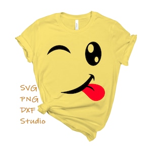 May include: Yellow t-shirt with a black and red winking smiley face graphic. The graphic has a tongue sticking out. The text "SVG PNG DXF Studio" is on the bottom left of the shirt.