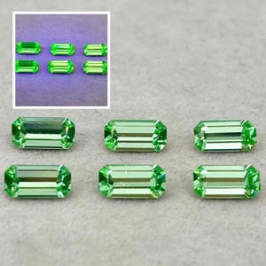 May include: Six loose baguette-cut gemstones with a vibrant light green colour. The stones are arranged in two rows of three, displaying a rectangular shape with faceted surfaces that reflect light. The inset shows the same stones under UV light.