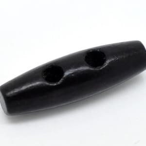 Peut inclure: Un bouton de toggle en bois noir avec deux trous. Le bouton est cylindrique avec des extrémités arrondies et une finition brillante. Idéal pour les manteaux, vestes ou autres vêtements.
